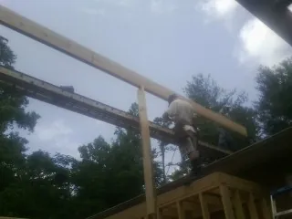 Carpenter setting a ridge beam over a new addition frame — Ice Dam Removal by Roofing Brothers in Milmay