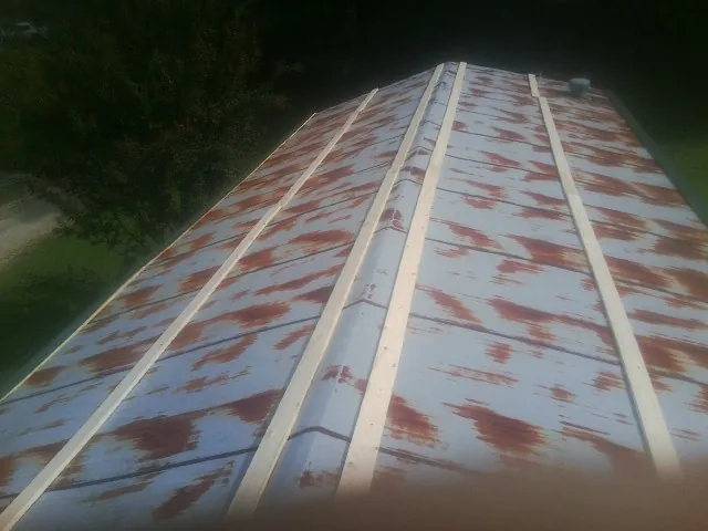 Rusted metal roof panels with new wood purlins before replacement — Storm Damage Roof Repair in Milmay by Roofing Brothers