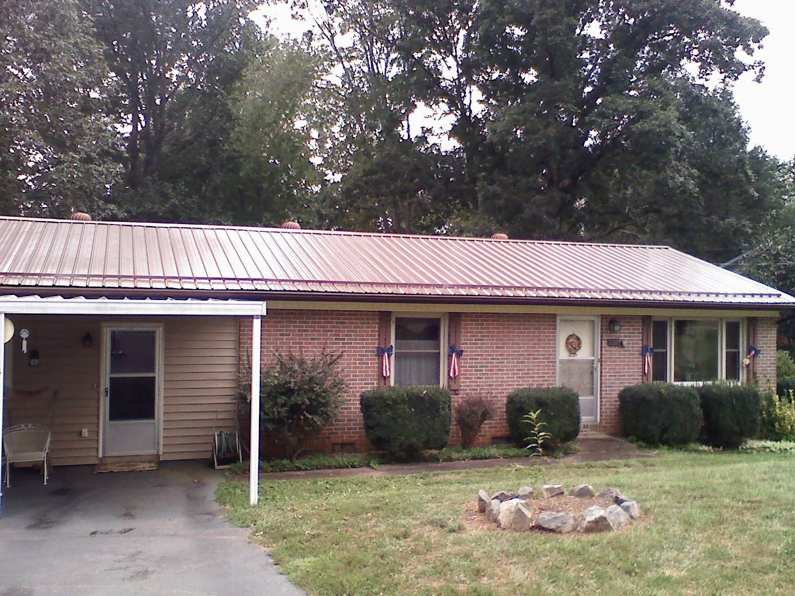 Bronze metal roof and carport on a brick ranch home — Roof Repair work by our crew in Milmay